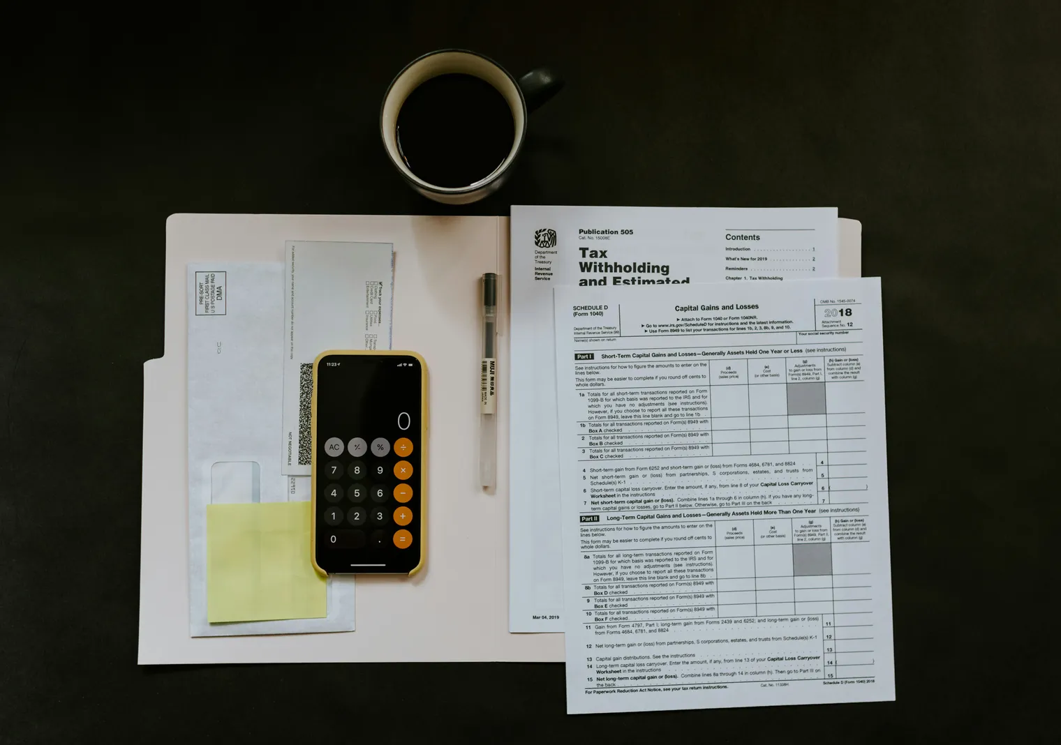 A calculator and tax paperwork laid out on a desk