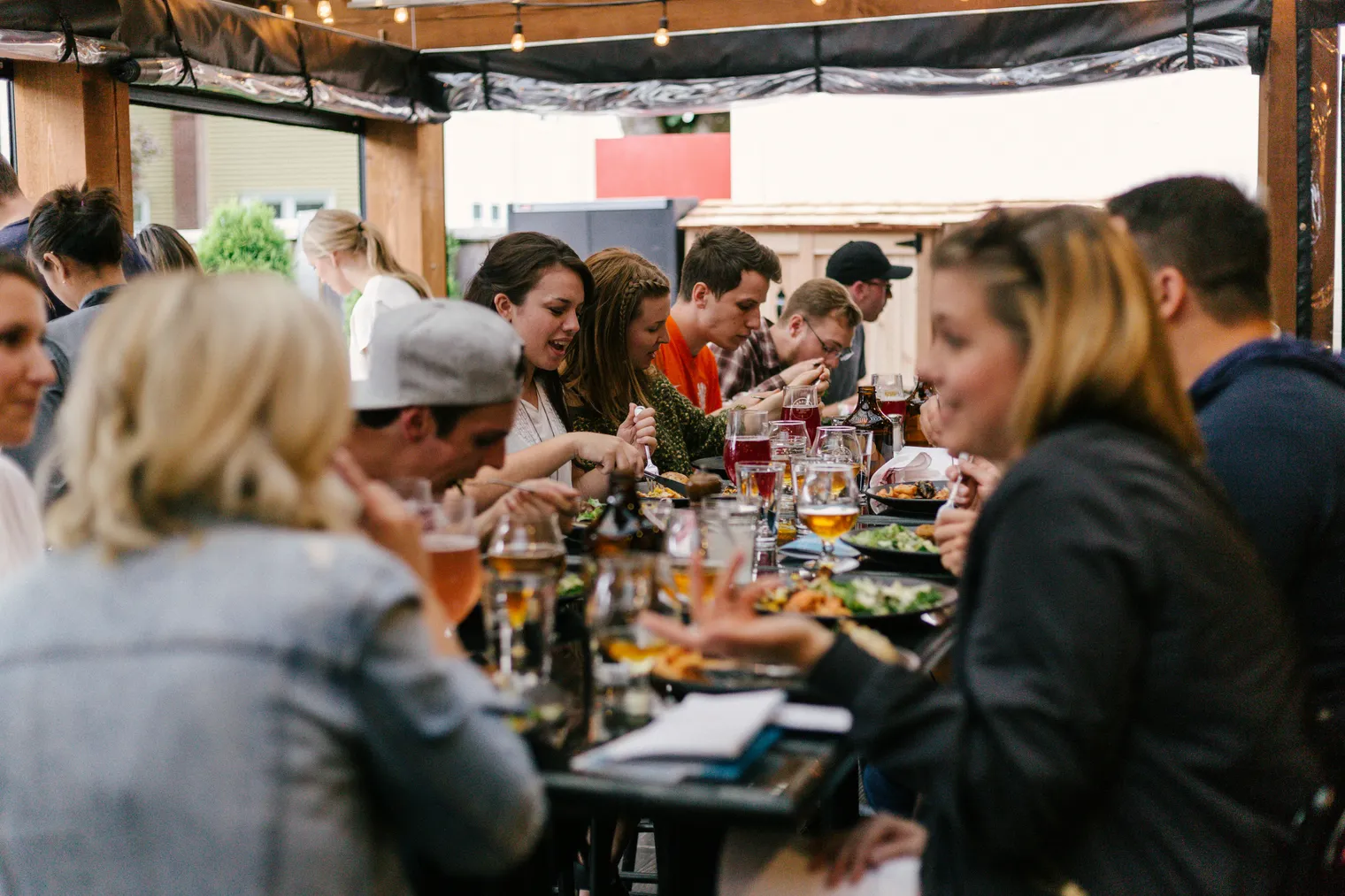A group of friends eating and talking around a restaurant table