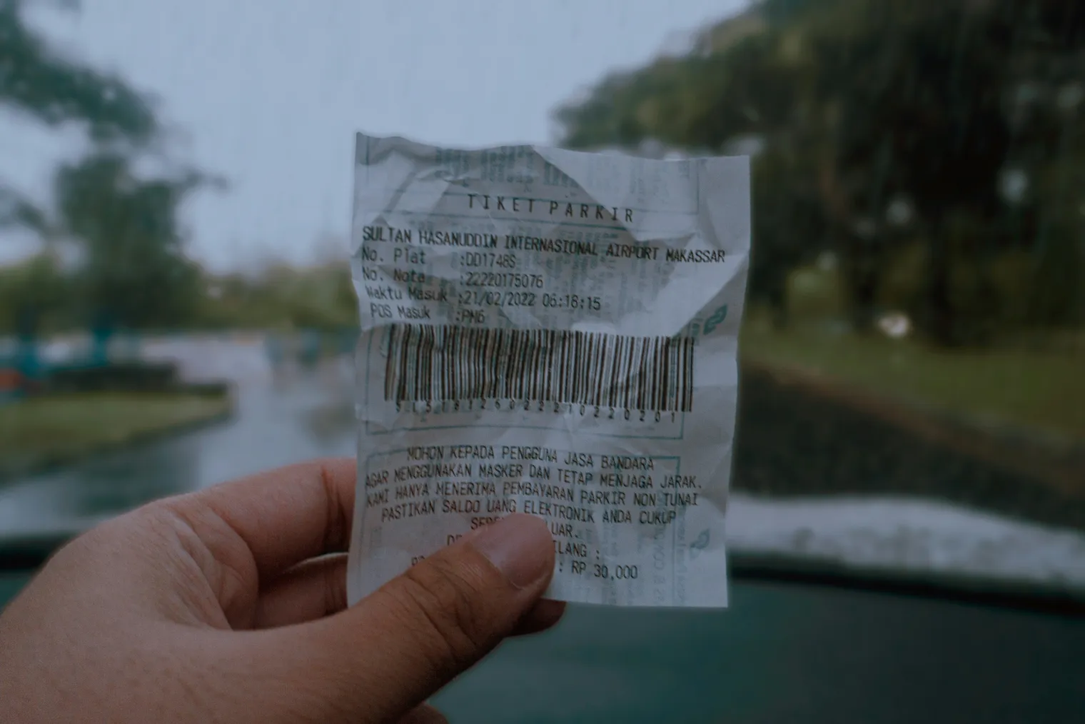 A hand holding a printed paper receipt