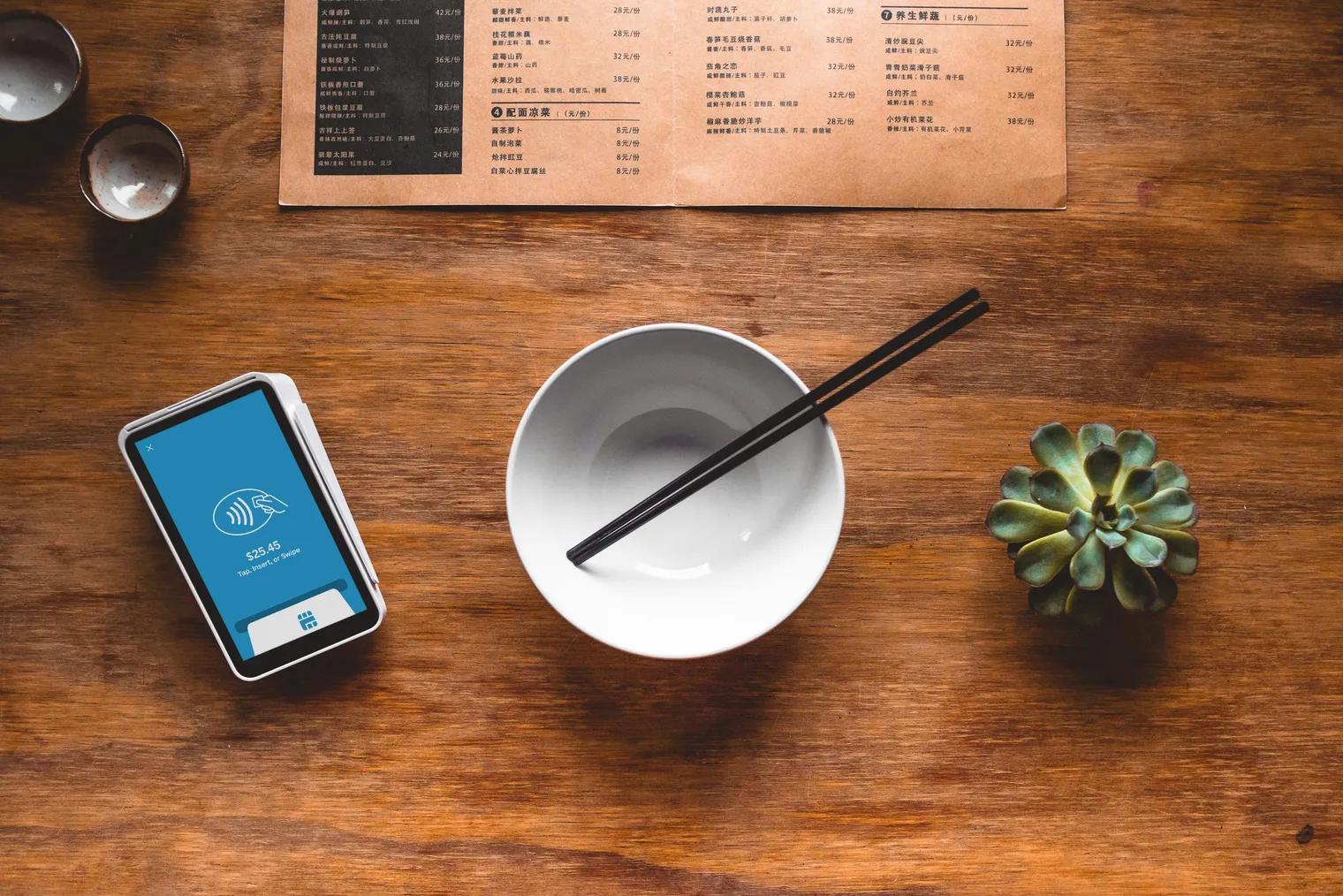 A restaurant bill and chopsticks on a wooden table